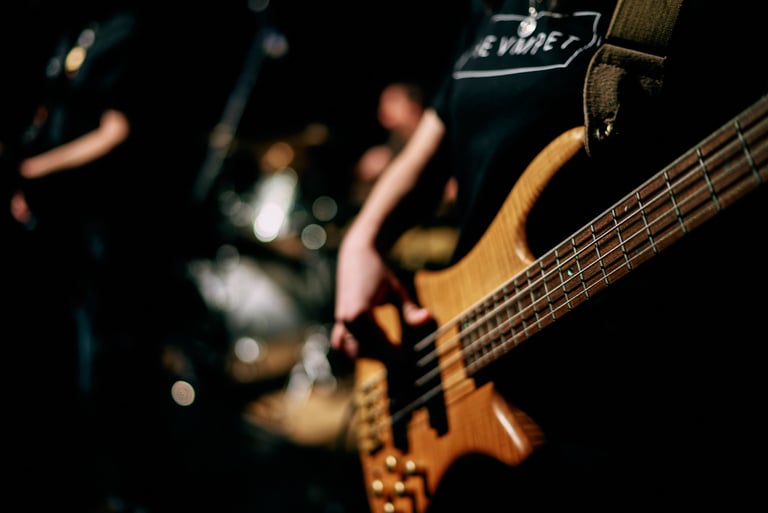 Close Up Photo of a Person Playing Bass Guitar